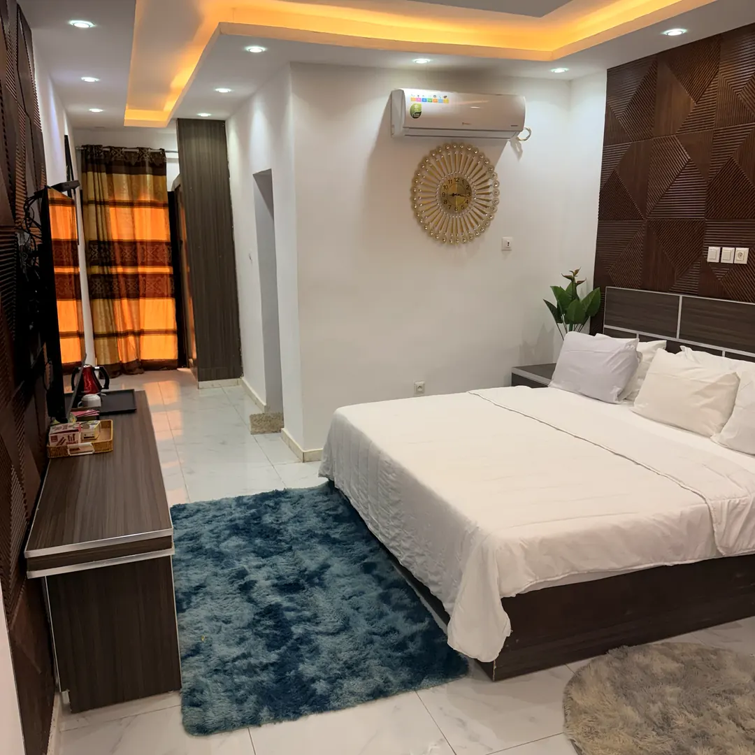 Chambre Double avec éclairage indirect, espace télévision et rideaux